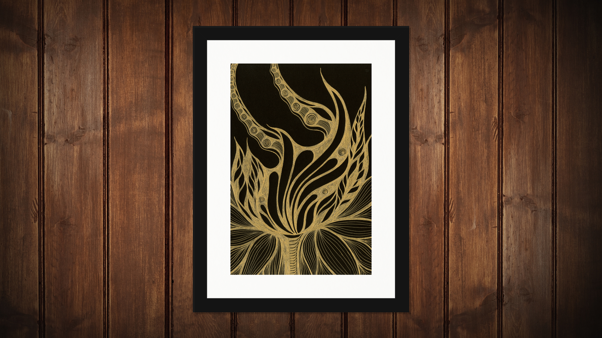 A framed art print featuring a gold tribal-style tree design on a black background, displayed against a dark brown wood-paneled wall.